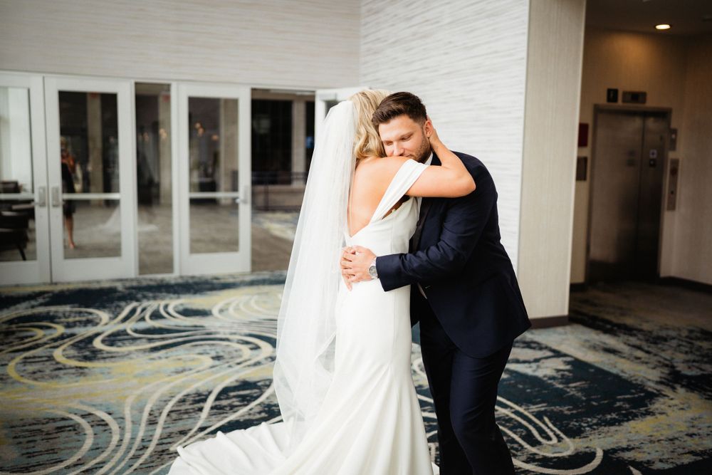 An emotional embrace captured during a wedding in a modern interior setting.