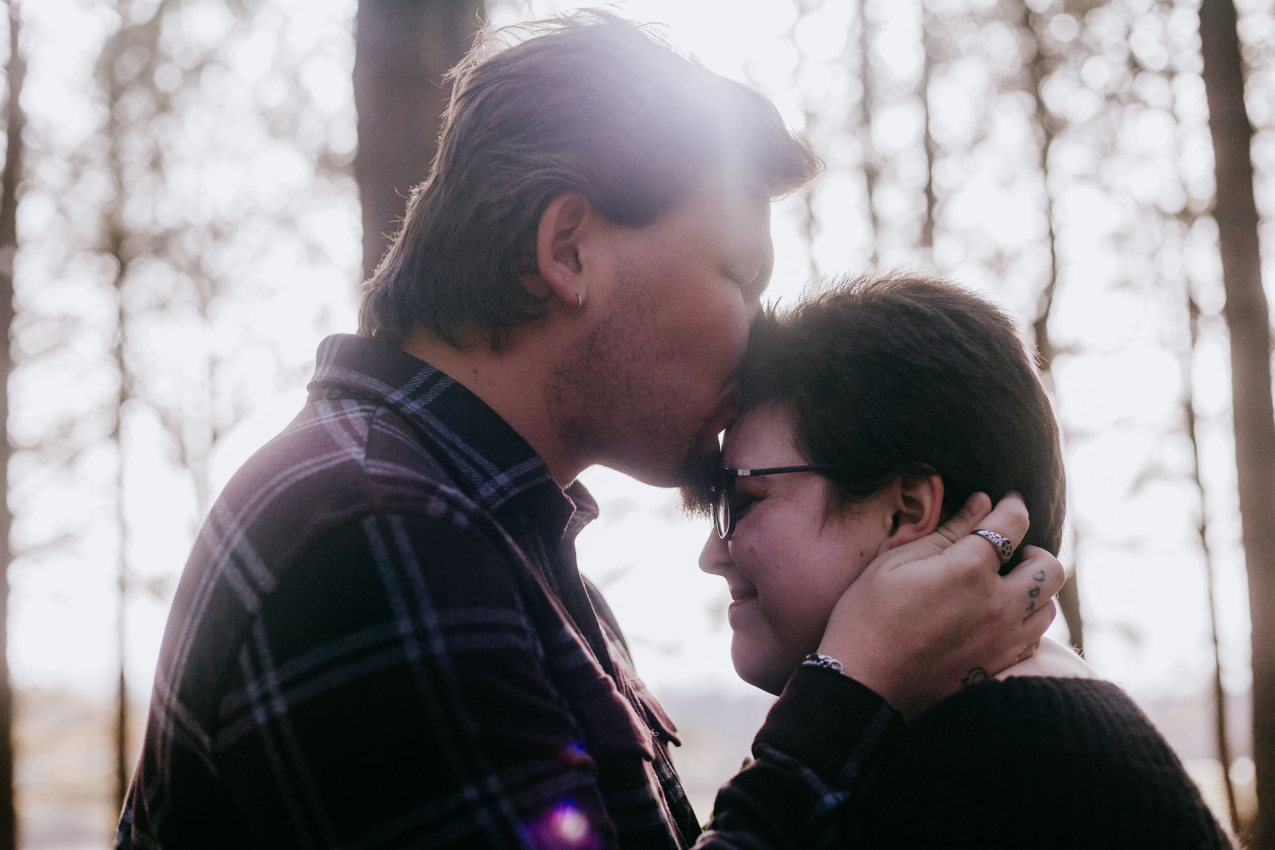 fiancé kisses his fiancée's forehead