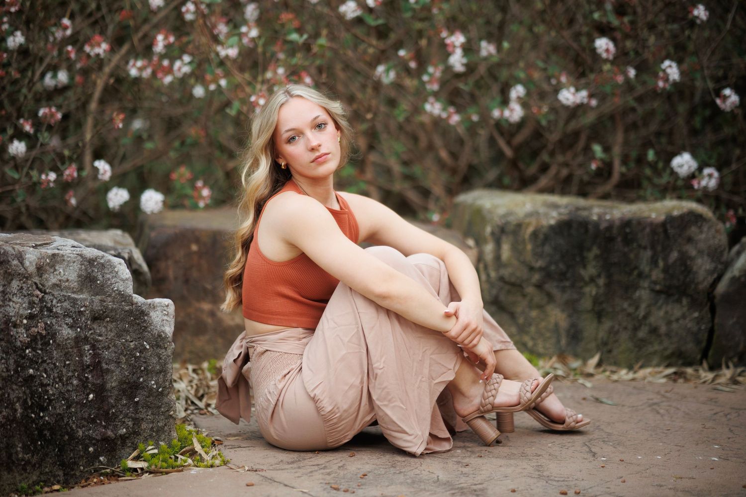 A peaceful portrait among blooming white flowers and stone walls.