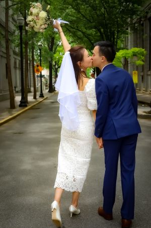 A playful wedding photo sequence on a tree-lined city street.
