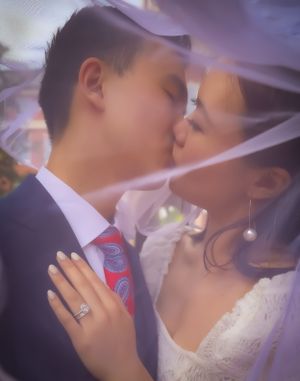 A romantic wedding kiss captured through a soft focus lens with delicate lighting.