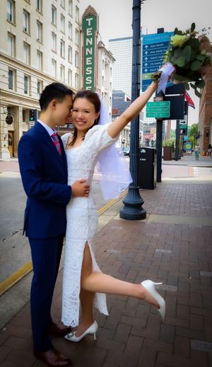 A celebratory dance sequence on a brick sidewalk in an urban setting.