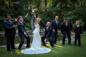 Wedding party celebrating outdoors with the newlyweds in a natural garden setting.