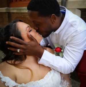 A tender embrace between newlyweds in a romantic indoor setting.