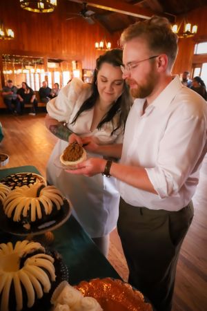 Wedding reception scene with bundt cakes being served in a rustic venue.