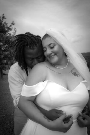 Black and white romantic wedding portrait captured outdoors with natural lighting.
