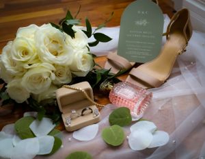 Wedding details featuring white roses and champagne bottles on a decorated surface.