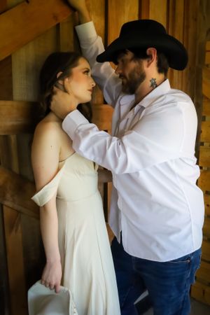 A romantic wedding photoshoot in a rustic barn setting with soft natural lighting.