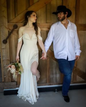 A couple shares a romantic dance moment in a rustic barn setting.
