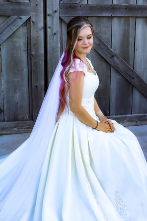 A bride in a stunning white gown twirls to show off the full skirt of her dress.