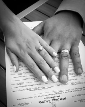 Black and white photo series of hands signing marriage license documents.