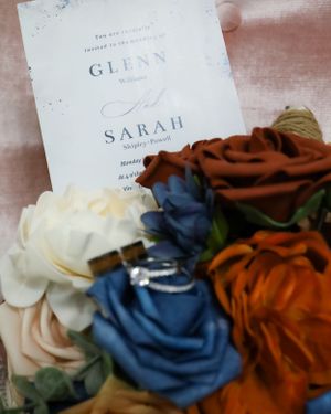Wedding invitation details with blue and rust colored roses.