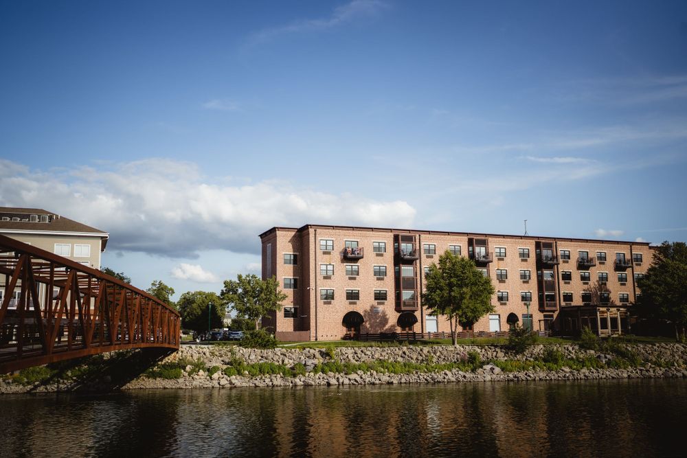 Brick apartment buildings along a waterfront on a sunny day.