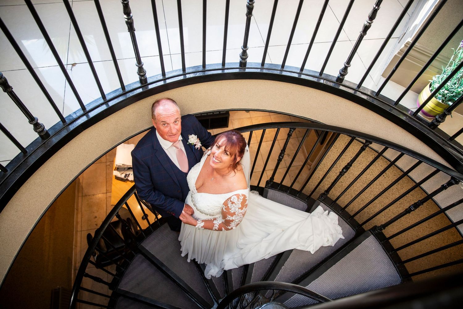 Artistic spiral staircase wedding photography shot from below.