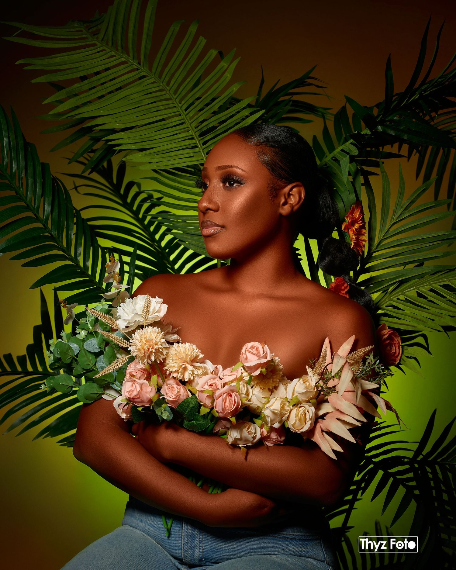 Artistic portrait with tropical palm leaves and delicate floral arrangement against a green and brown gradient background.