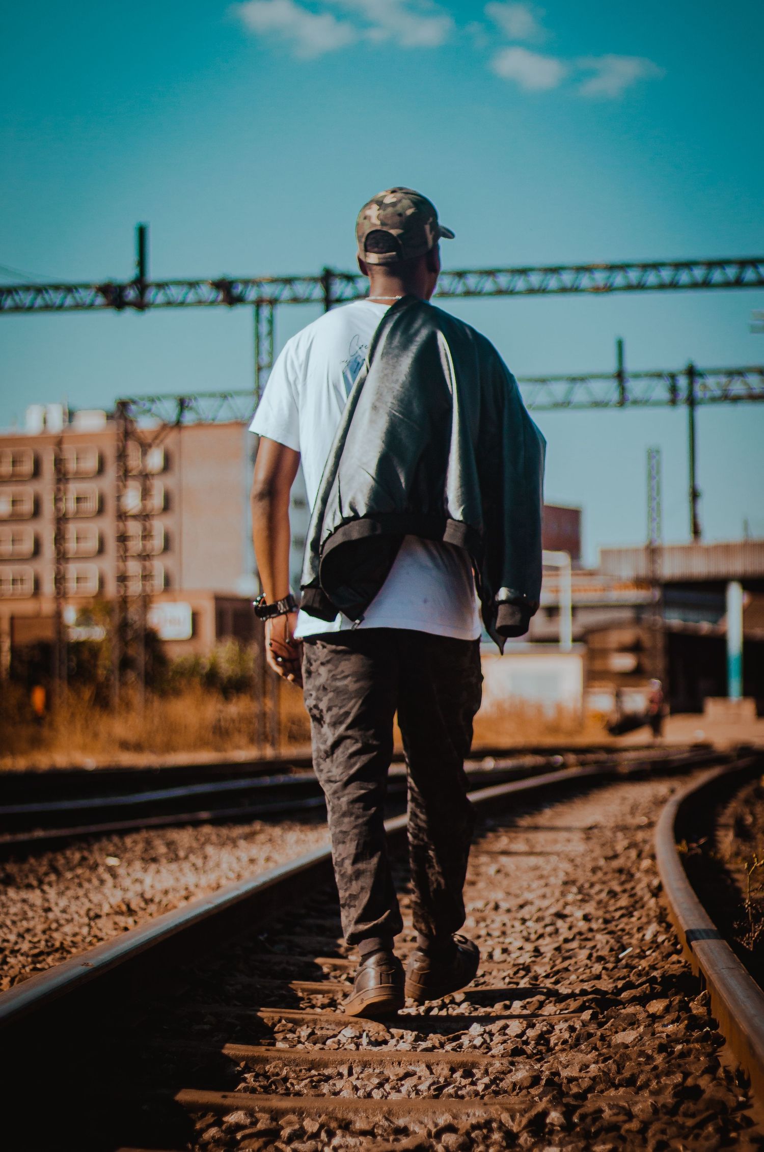 man walking on train tracks