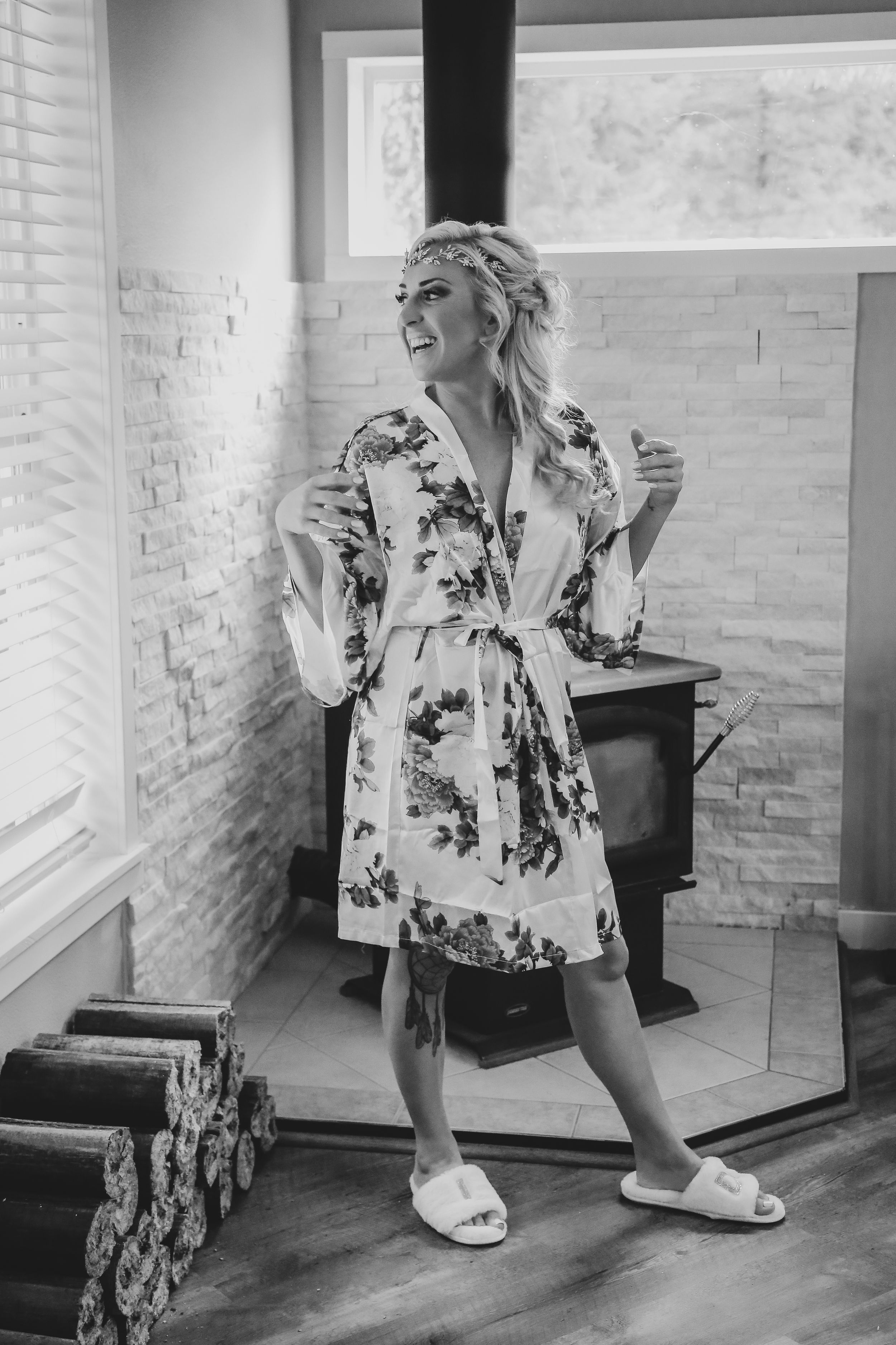 A person in a floral robe dancing joyfully in a bright interior space.