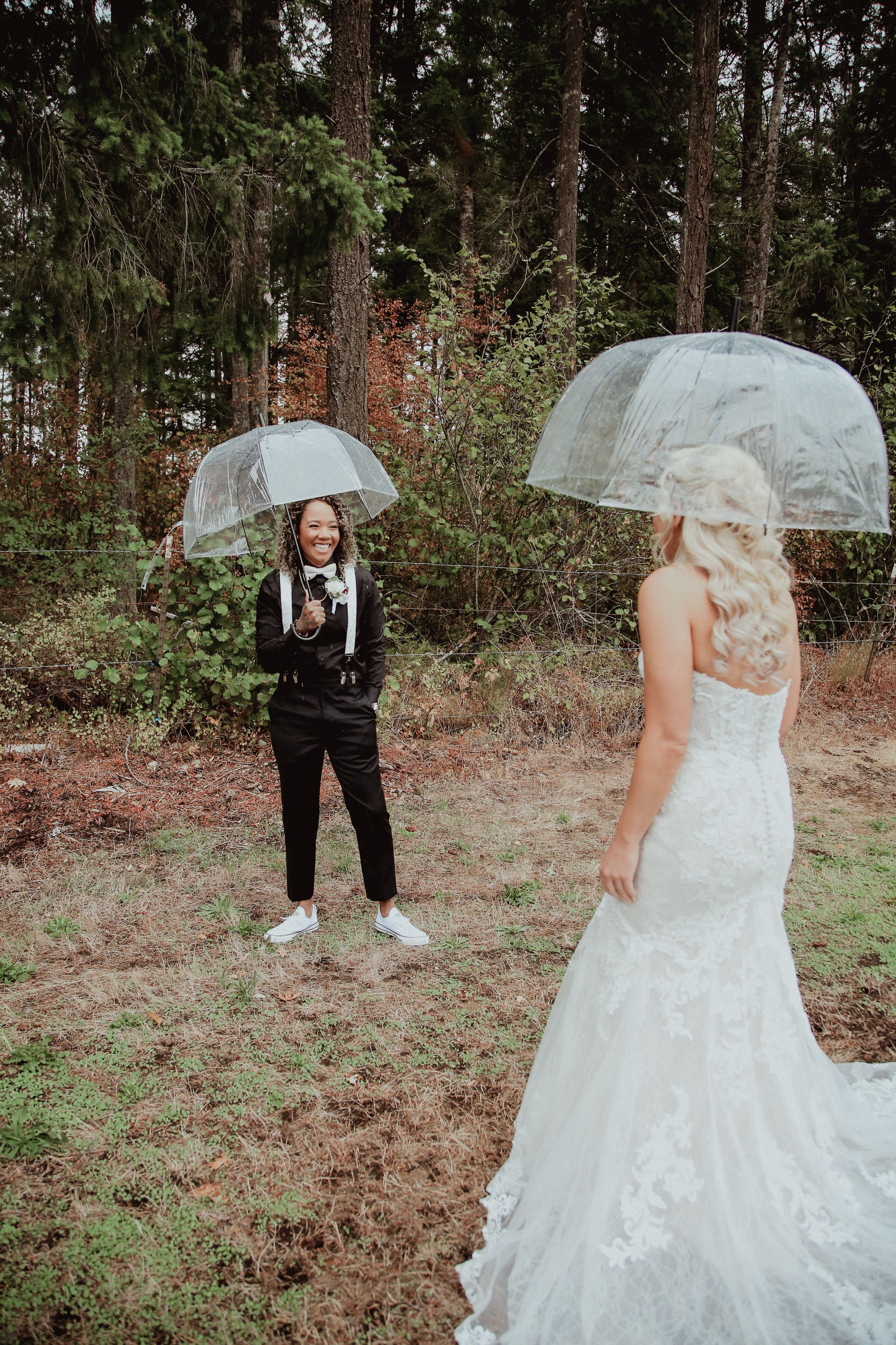 Wedding photo shoot in a forest setting with clear umbrellas.