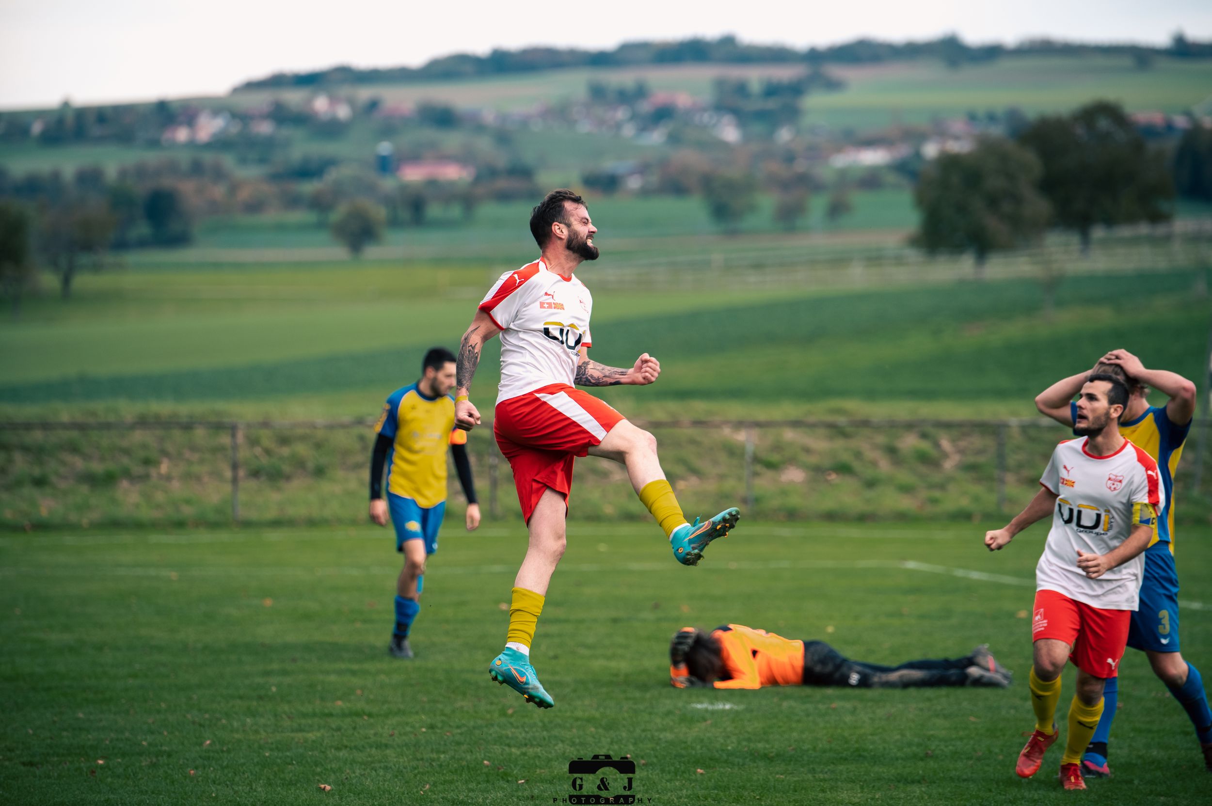 Soccer players compete intensely on a green grass field during a match.