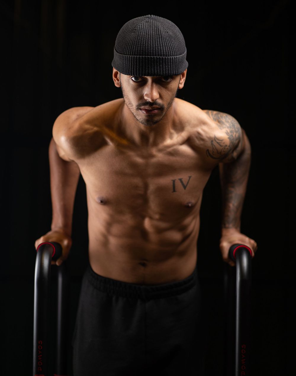 Athletic figure in beanie performing dip exercise showing muscular physique.