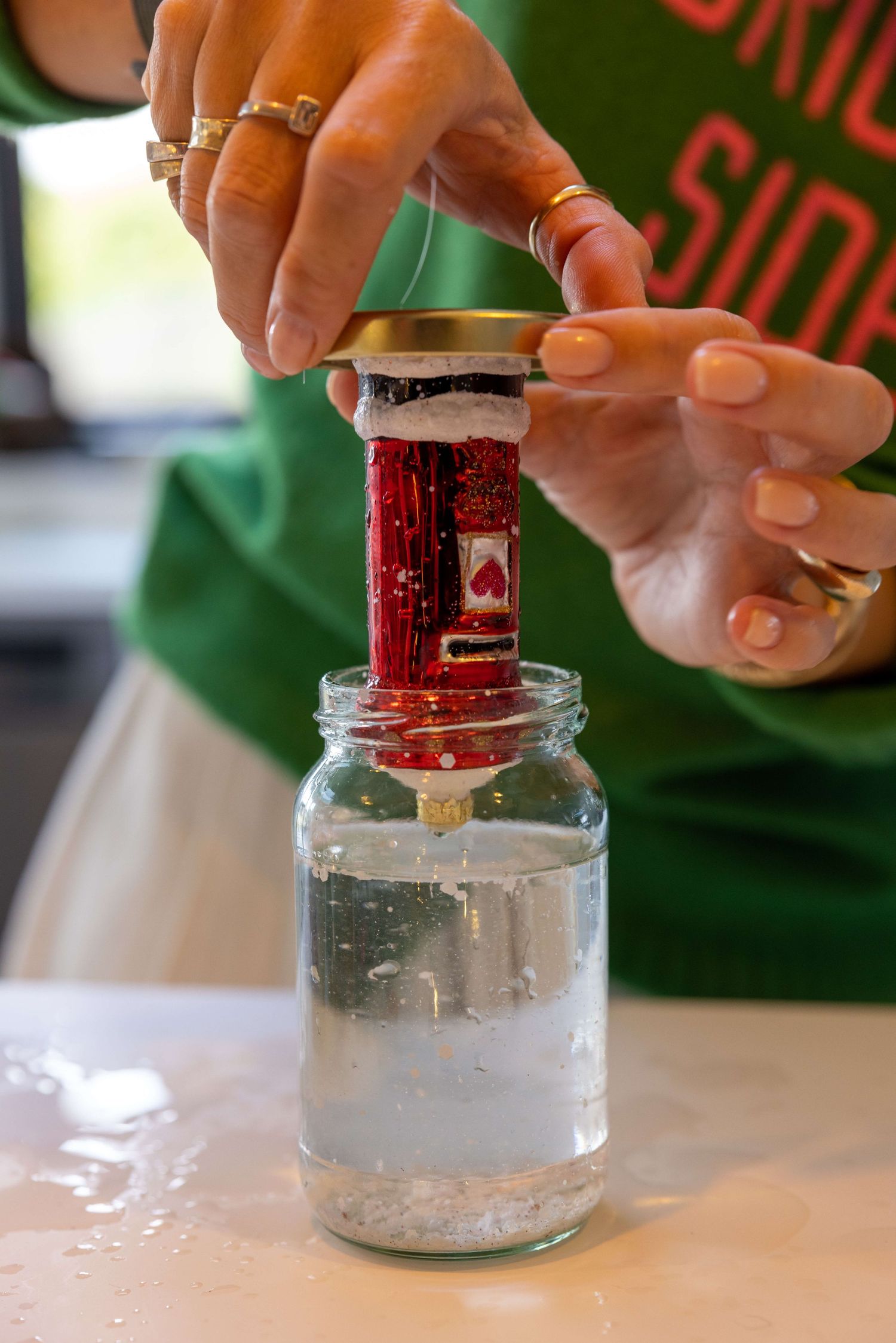 Jess putting a mailbox into a jar to make a snow globe for an ad on instagram shot in her home