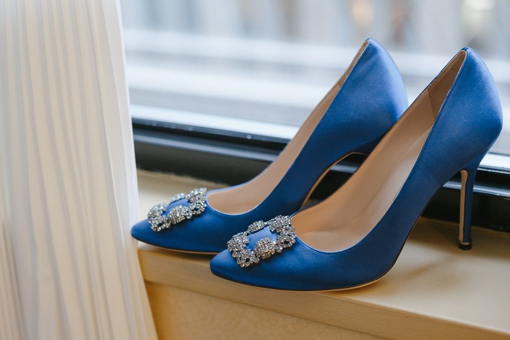 a pair of something blue Jimmy Cho shoes on a windowsill, photo by NYC elopement photographer Paula Ortiz
