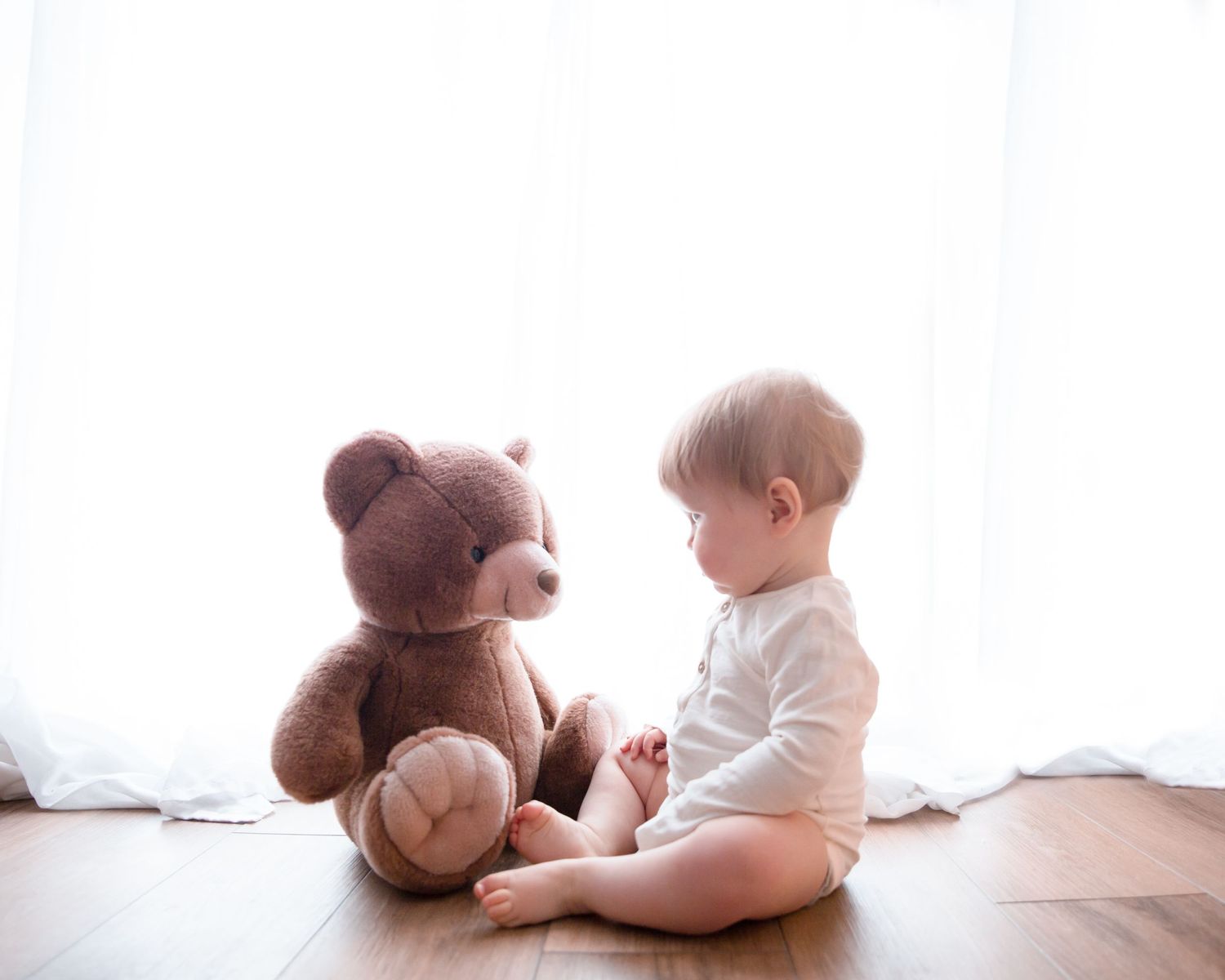 baby boy sitting with teddy bear