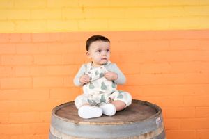 cute white sitting baby with orange background