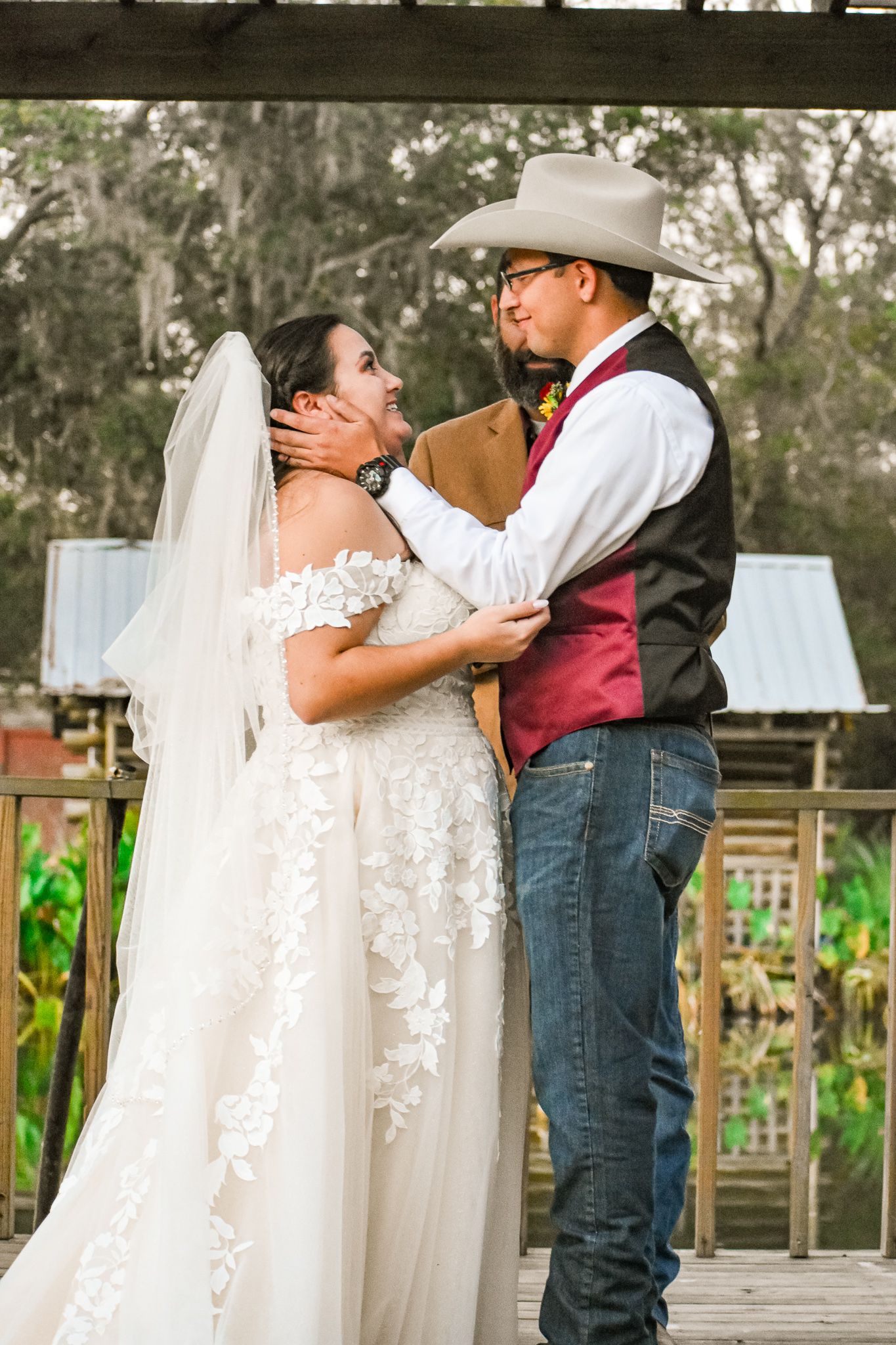 Country western themed wedding couple sharing intimate moment on wooden deck.