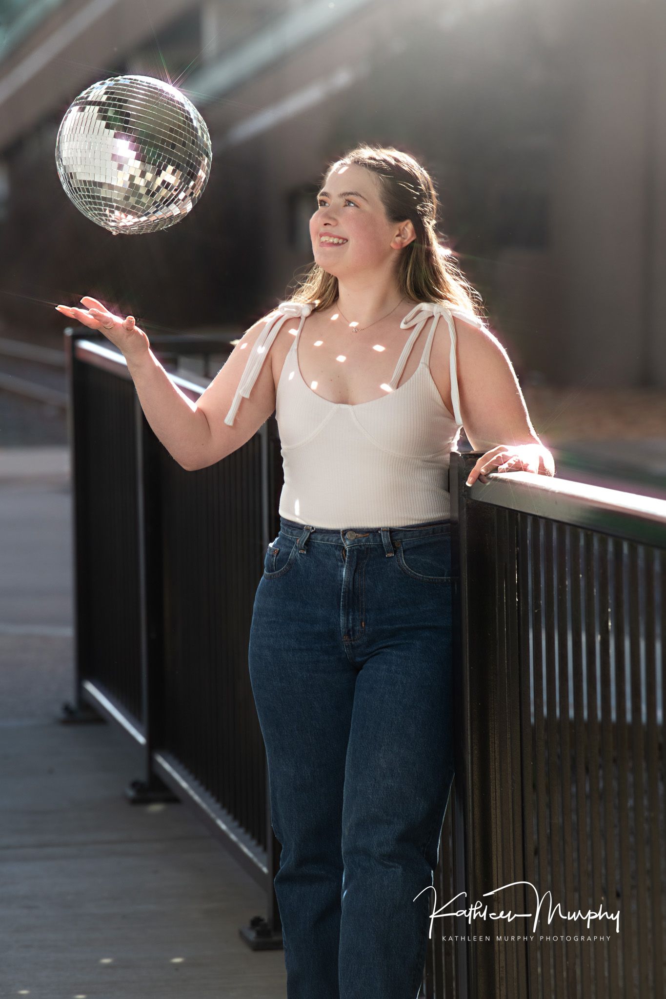 Casual portrait with floating disco ball on wooden deck.