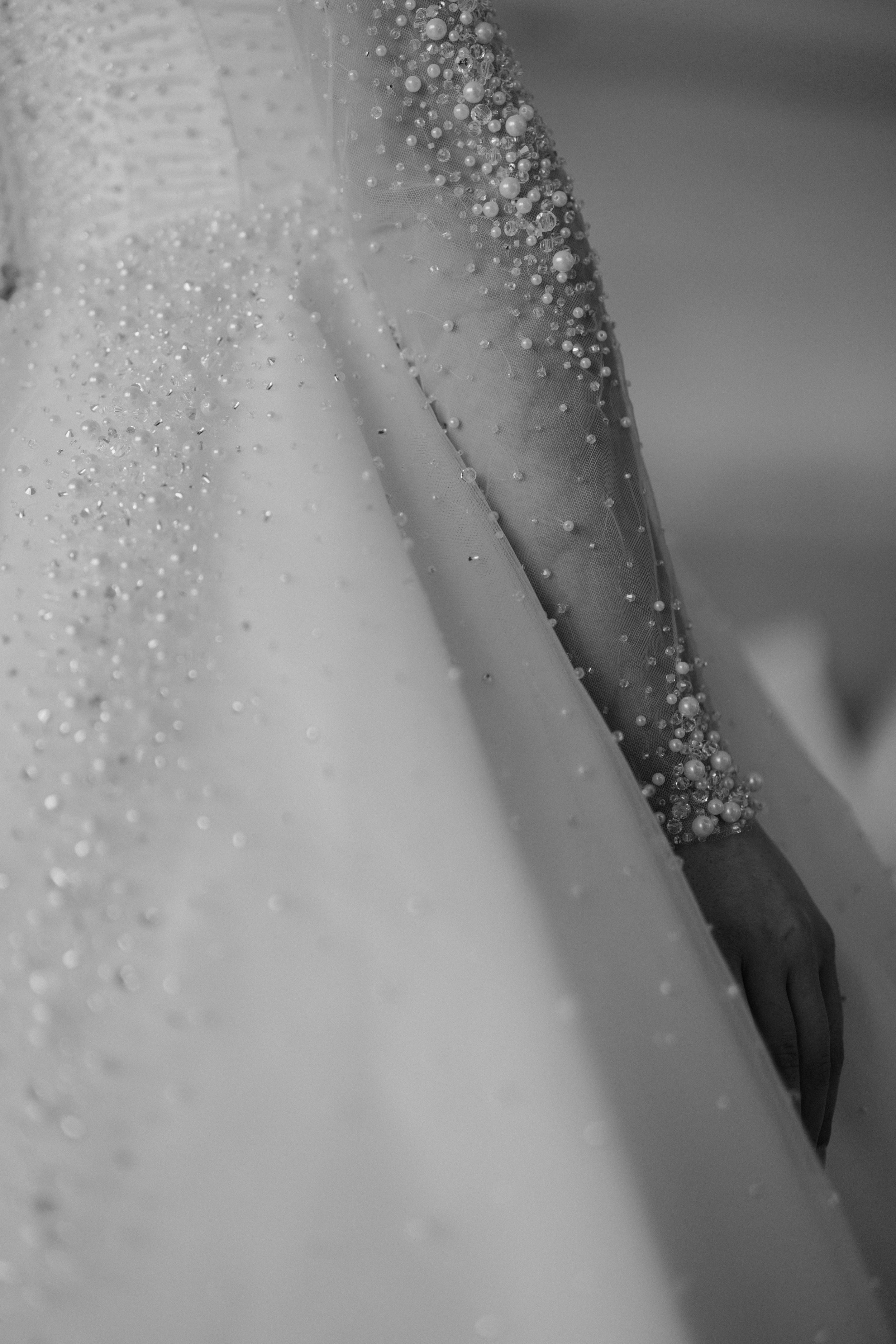 Macro shot of wedding dress beading and sparkles in black and white.