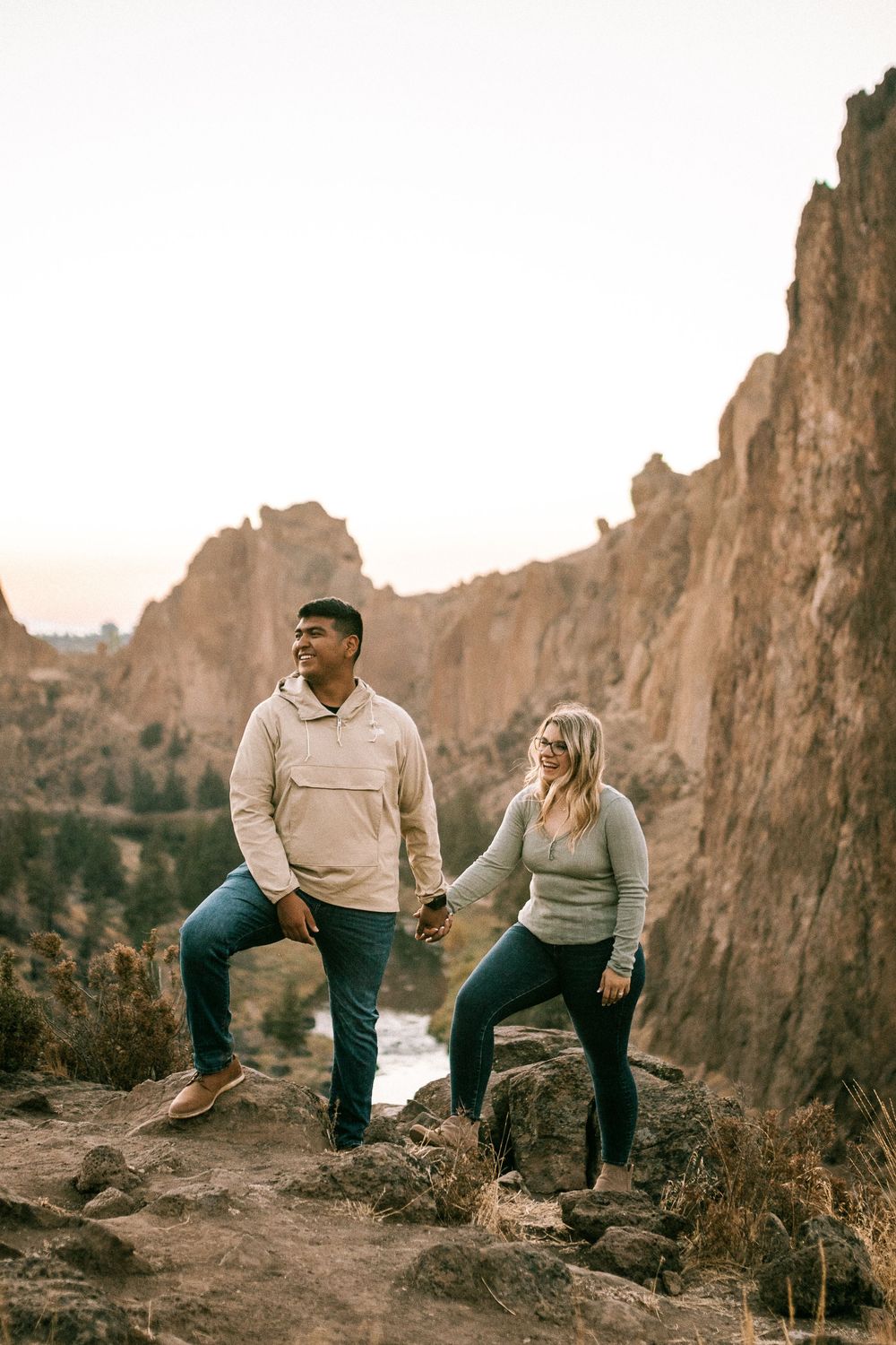 Adventure couple hiking together on rocky terrain at Smith Rock State Park.