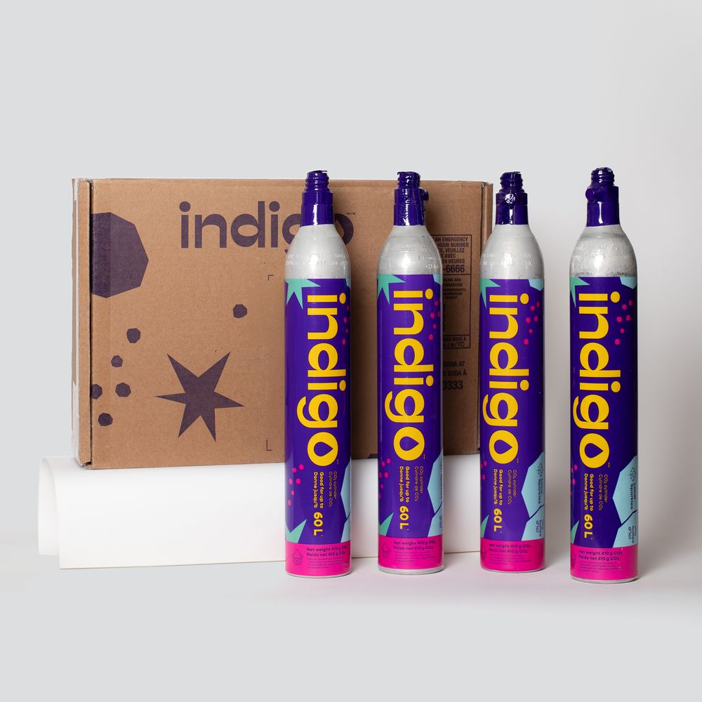 Four Indigo 60L purple CO2 carbonation cylinders displayed in front of an Indigo branded cardboard box.