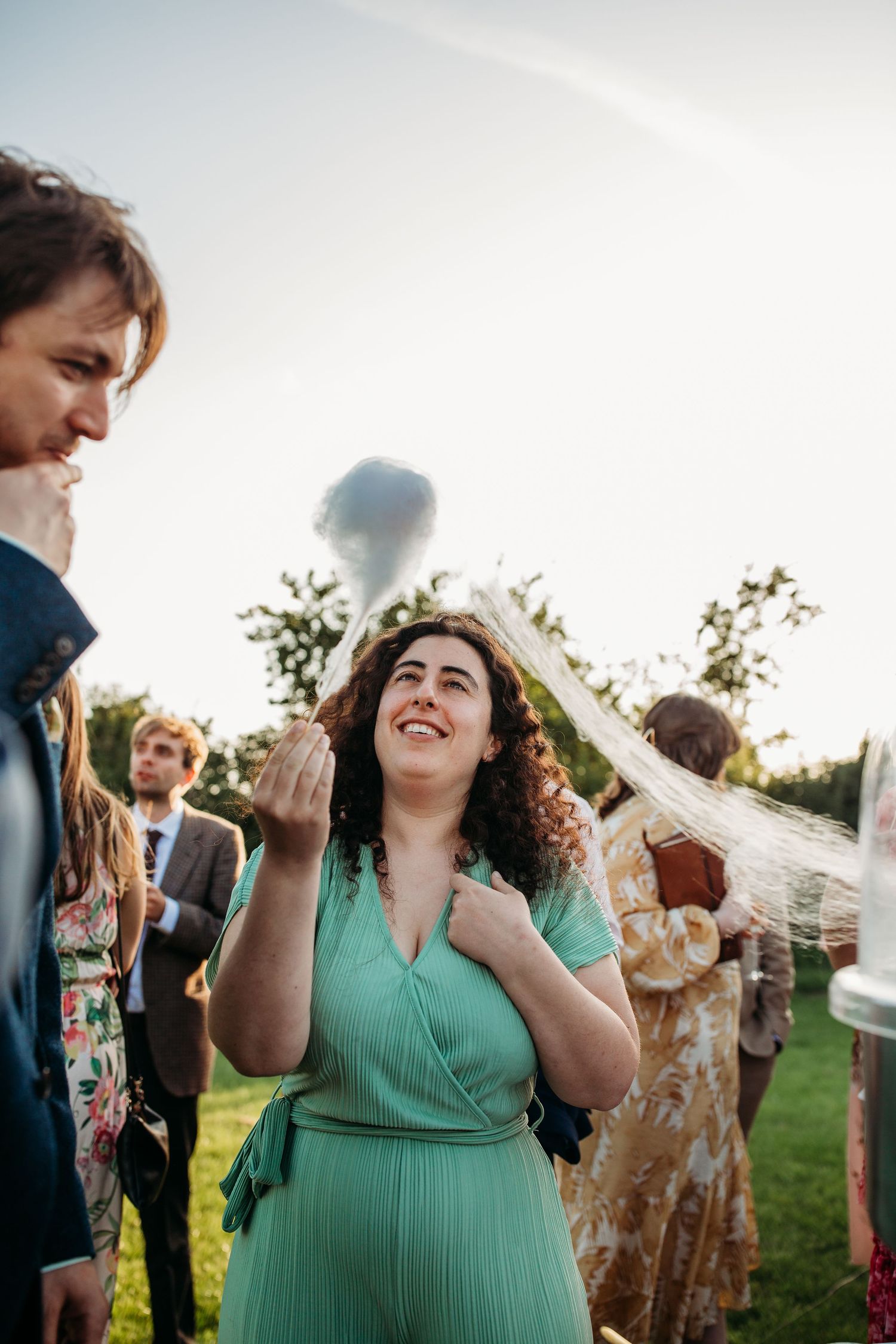 Wedding guests in colorful attire share a joyful moment during an outdoor celebration.