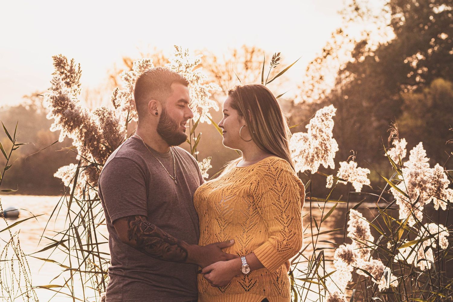 Happy couple smiling at each other at  golden hour behind a warm scenery