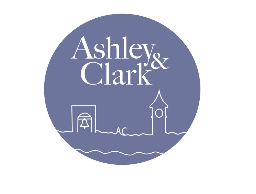 Circular blue logo design for Ashley & Clark featuring a simple church skyline silhouette.