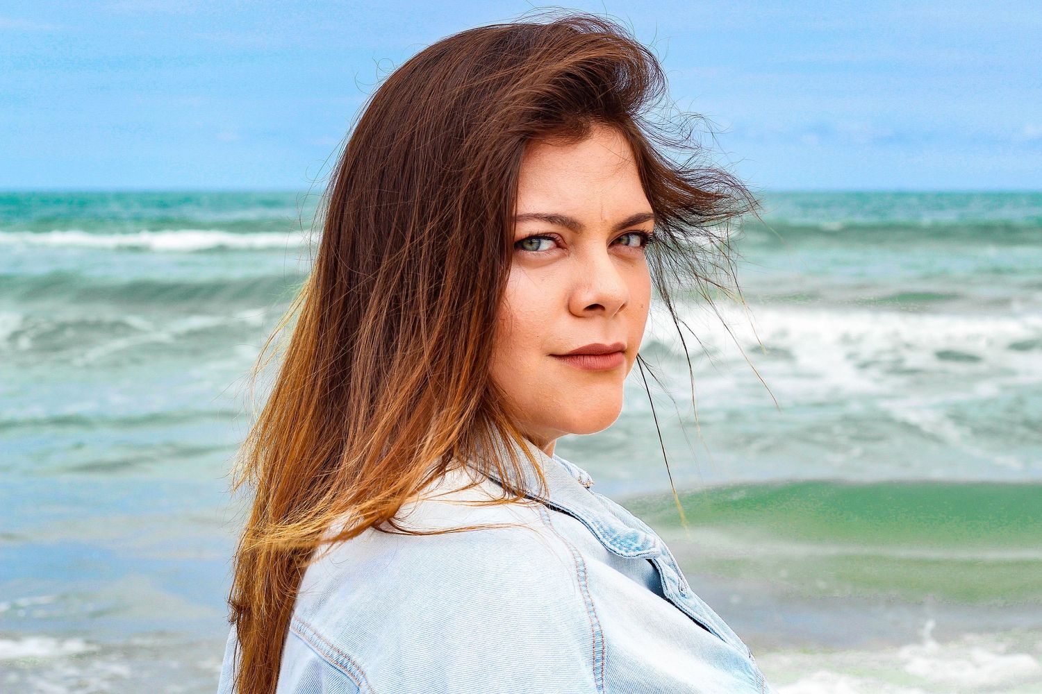 Girl looking at camera on a beach in the winter