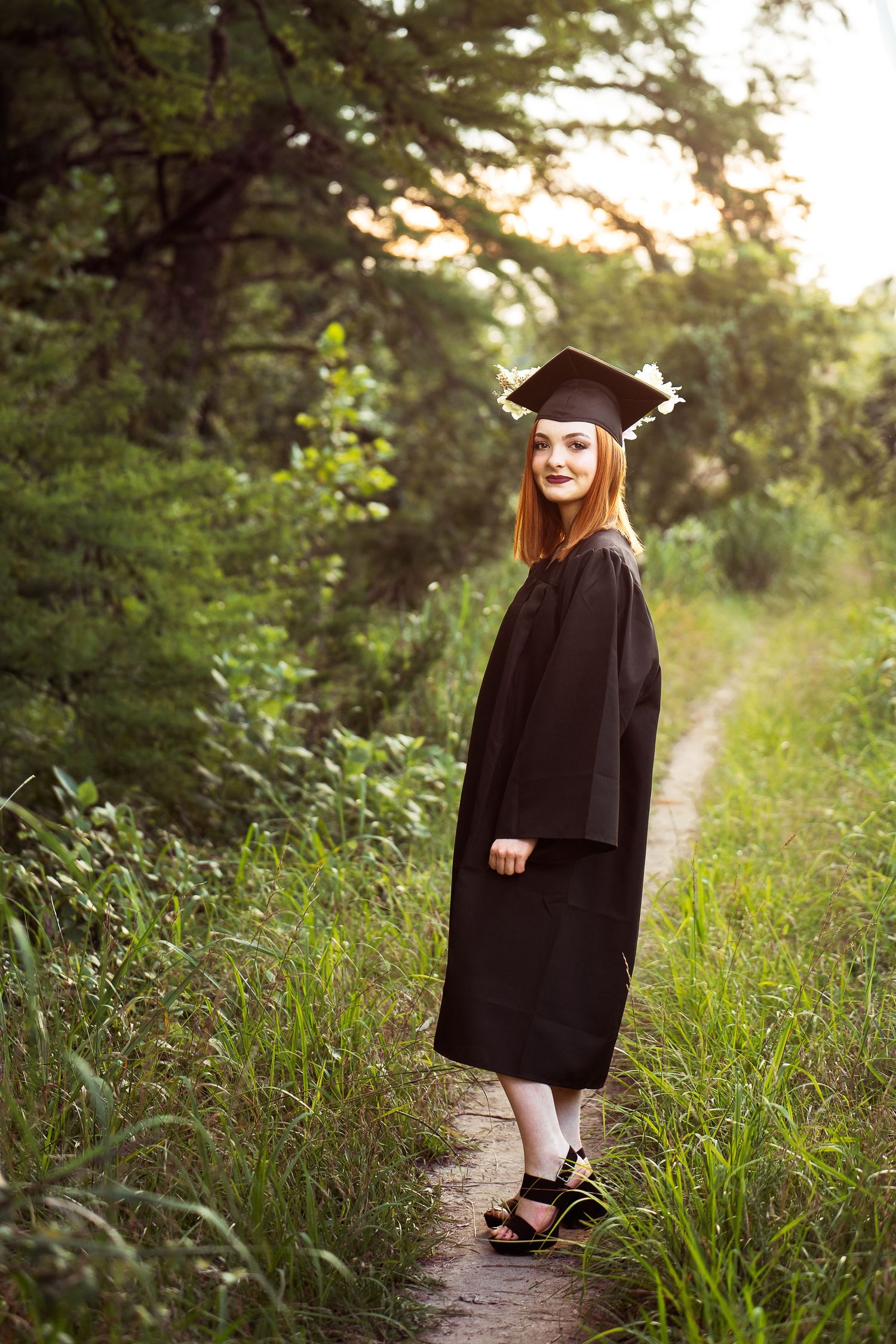 Cibolo Creek Nature Center portrait of high school senior girl in cap and gown standing on pathway