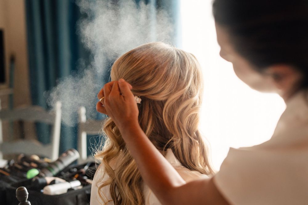 Hairstyling session with professional tools and morning light through window.