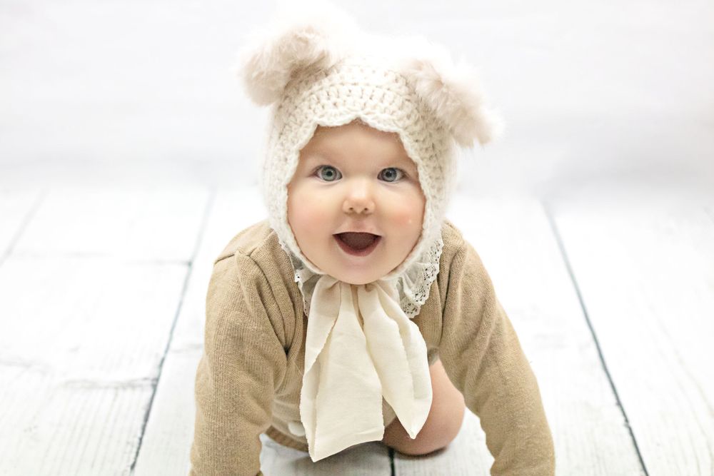 baby boy crawling in brown outfit and bear hat photographed by newborn photographer swansea