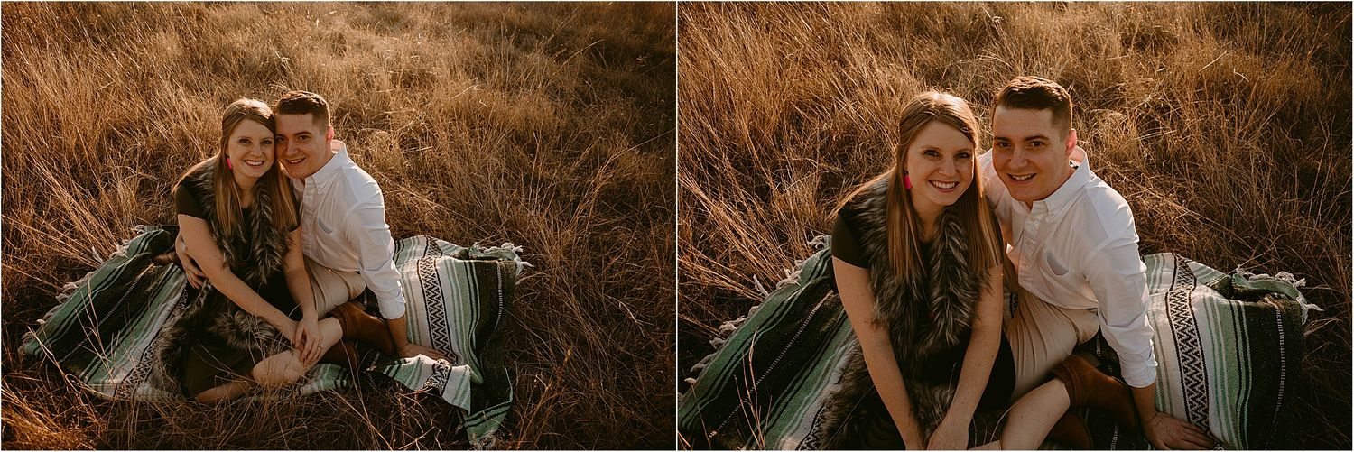 Couple sits together on blanket in golden field during sunset photo session.