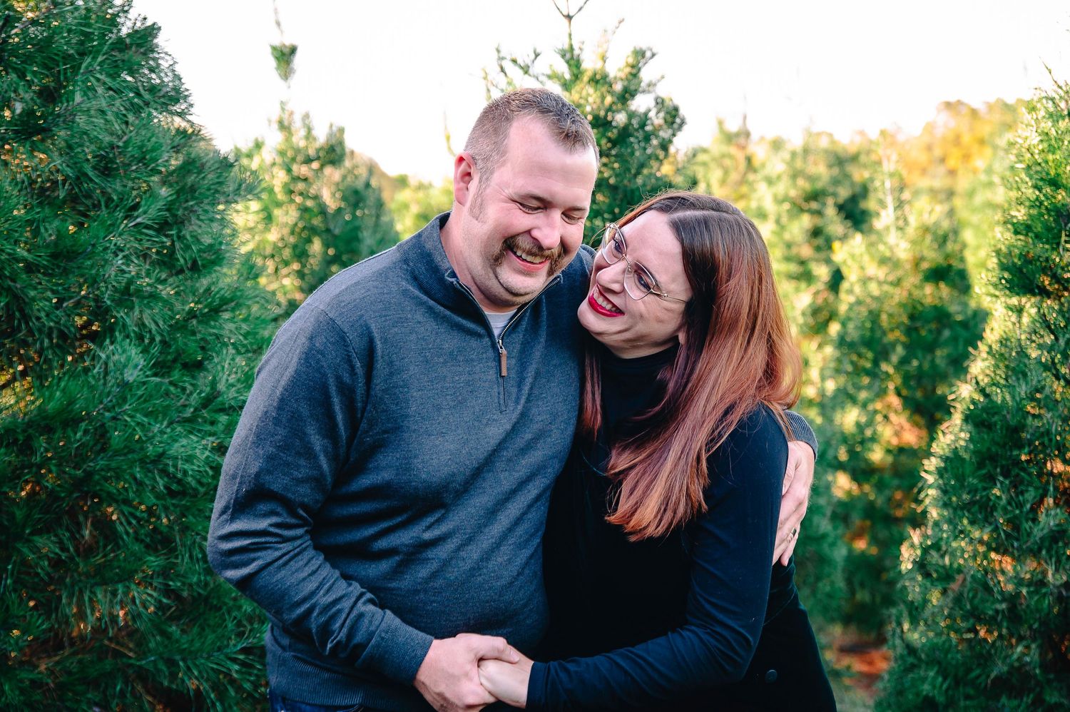 Fun couple laughing at Christmas tree farm in owasso