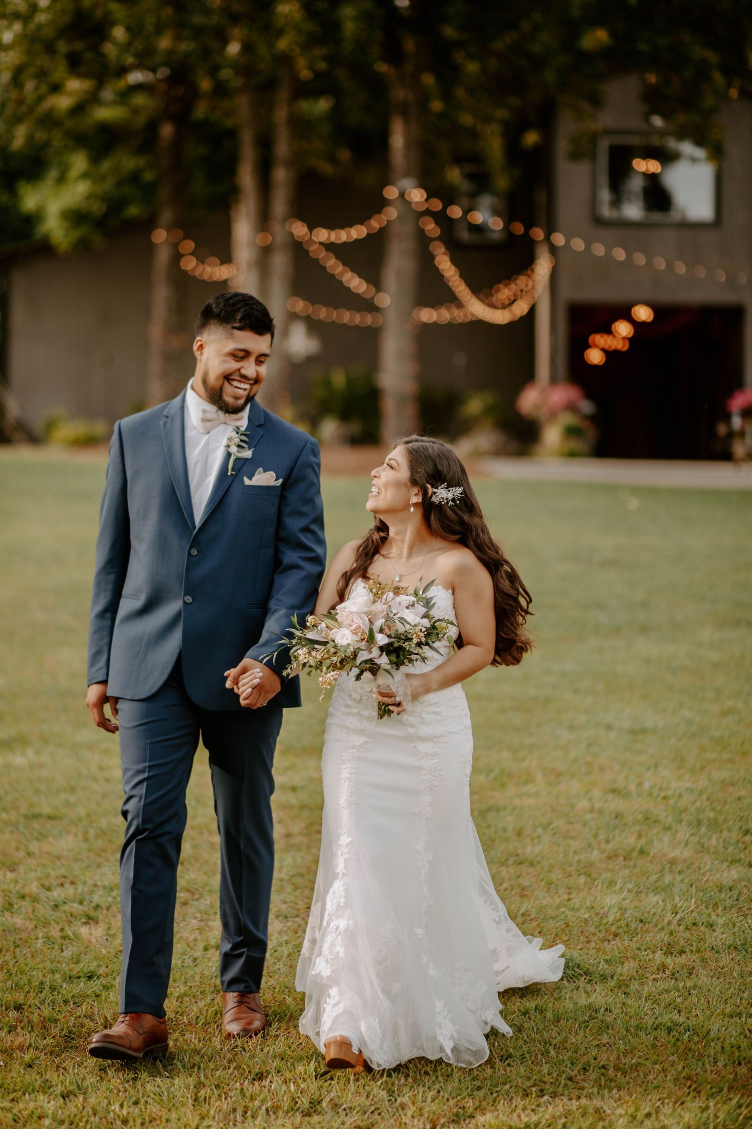 Newlyweds walk away from the wedding ceremony with big smiles, holding hands.