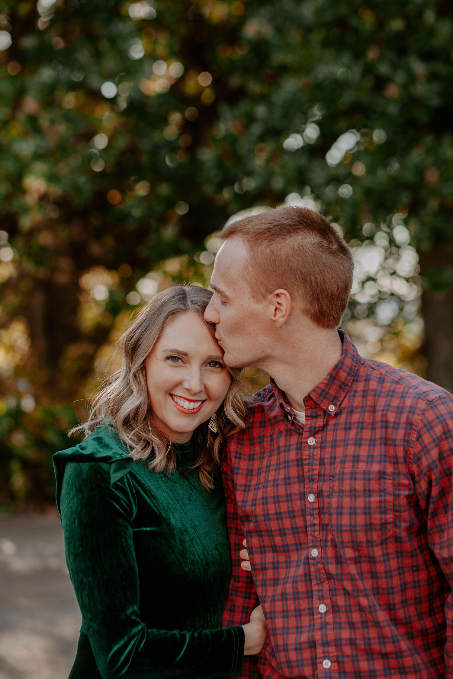 Husband kisses his wife's forehead during a family session with Anna Holman Photography.