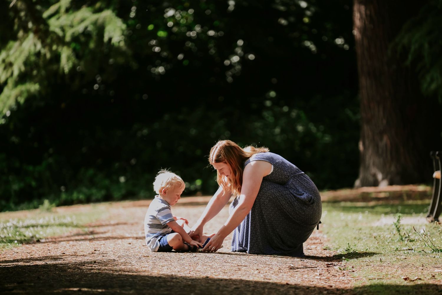 Sweet outdoor moment between parent and child sitting together on a forest path.