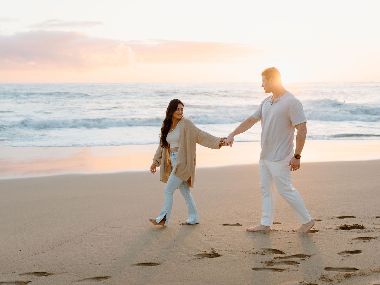 Couples photo session on Oahu in Hawaii with a man and woman holding hands while walking on the beach Moments With Kell