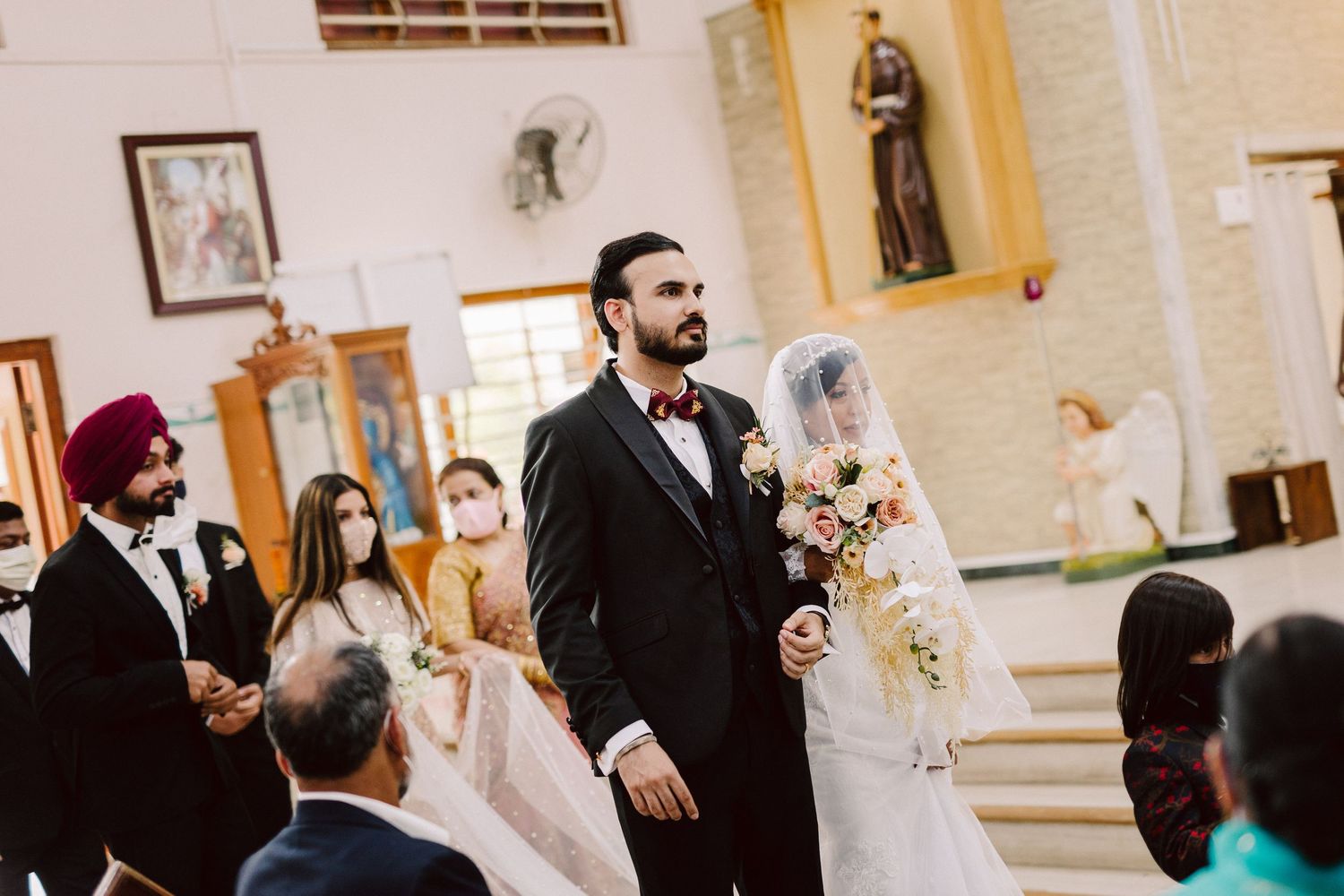 Traditional church wedding ceremony with decorative interior and guests in attendance.