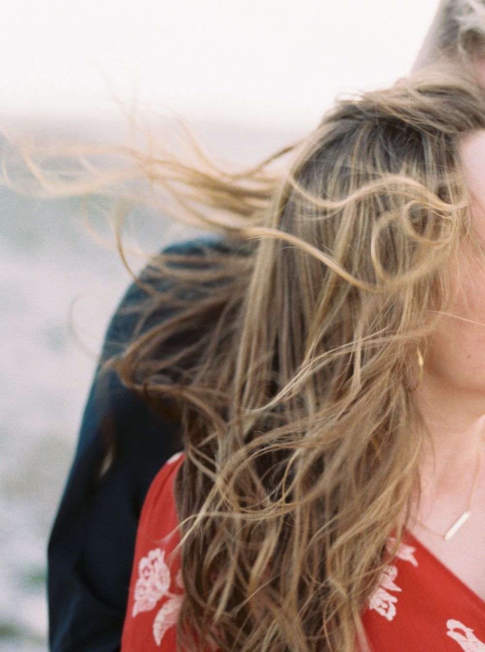 Close-up of windswept blonde hair against a blurred background.