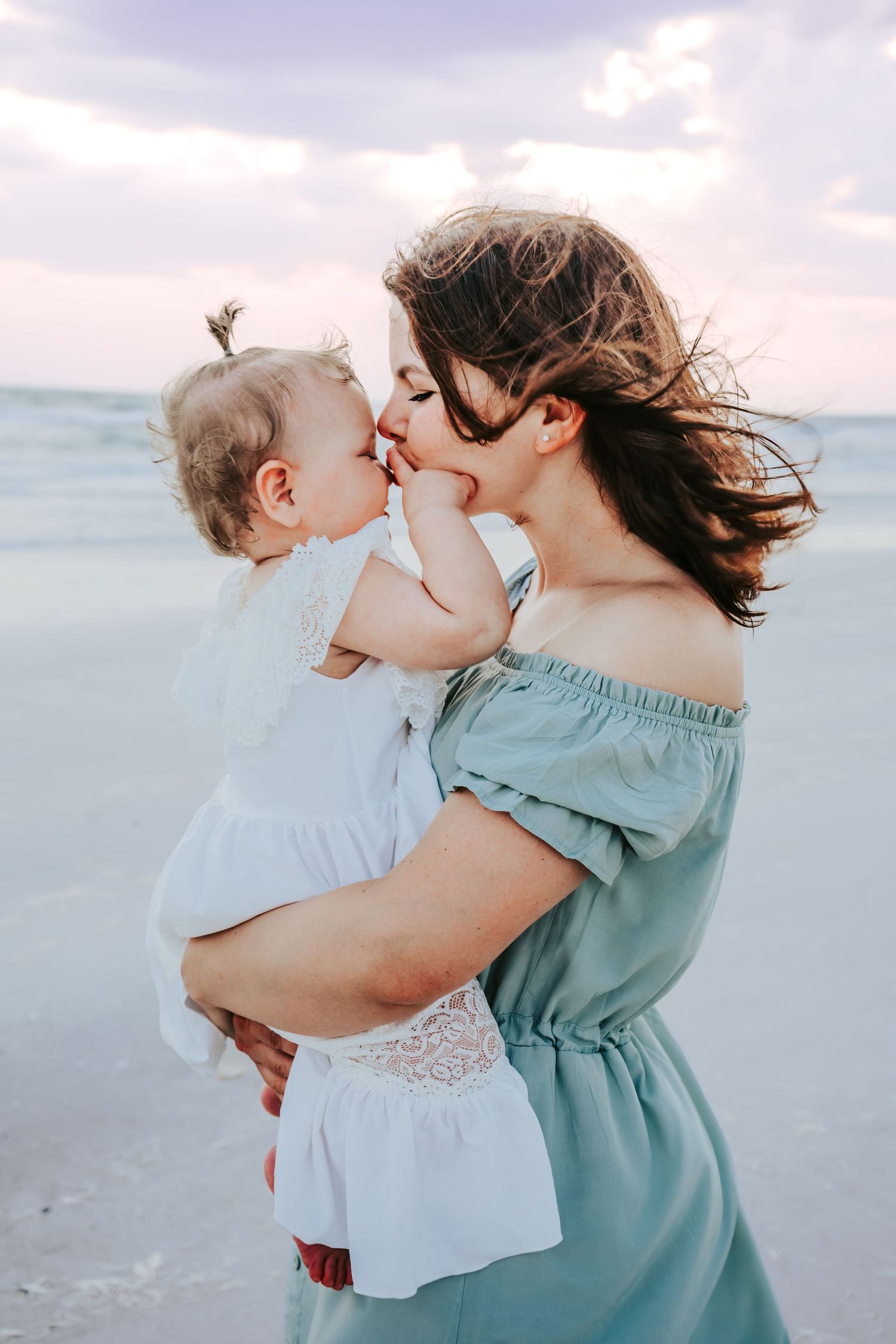 Outdoor Family Session at Indian Rocks Beach in Indian Rocks, FL; mom kissing babies nose on beach