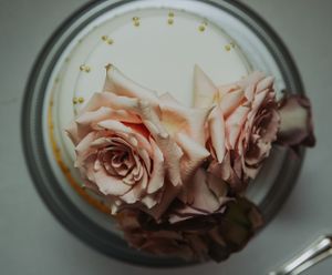 Delicate pink roses arranged in a clear glass jar with golden accents.
